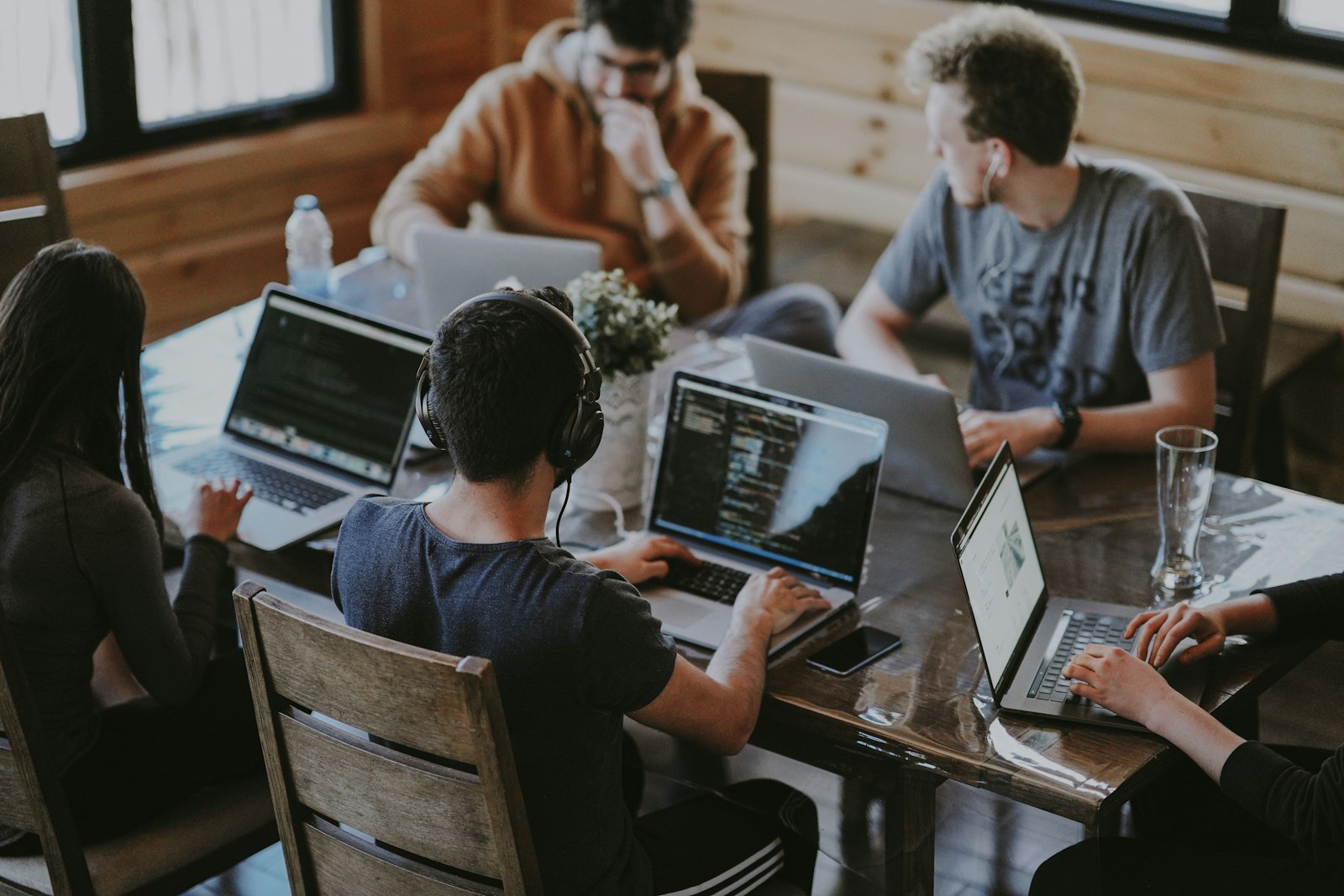 Technical team in discussion around computers in a modern office